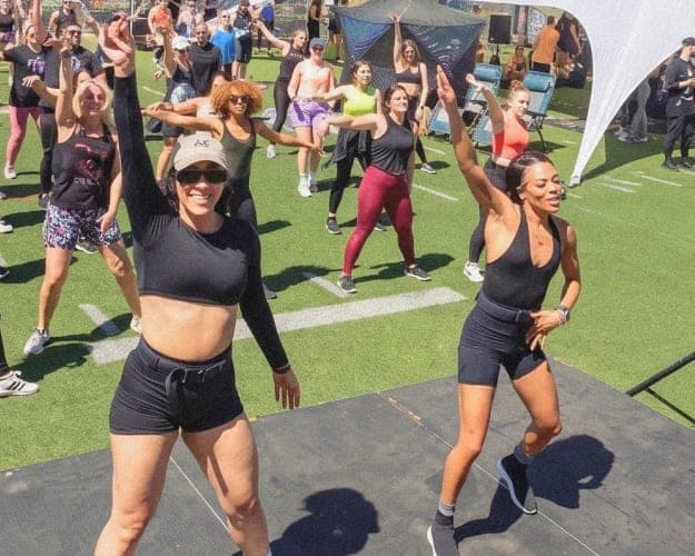 A Sweatpals host leading an outdoor fitness class